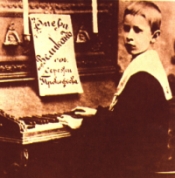 Prokofiev, a sus 9 aos, sentado al piano con la partitura de su pera Gigante